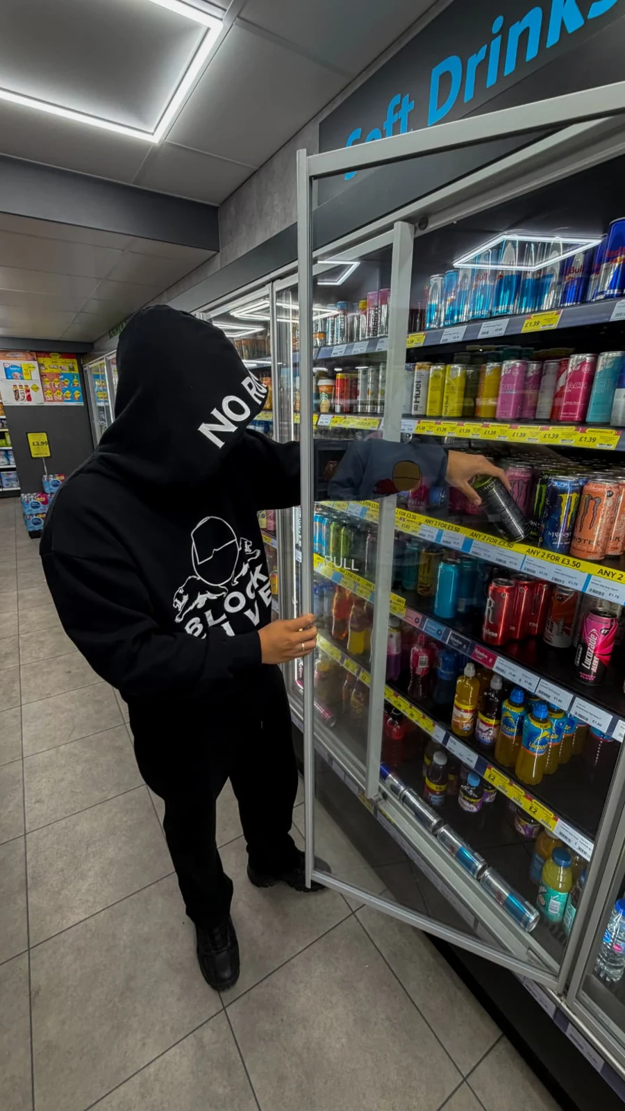 Black BLOCK FIVE hoodie worn beside a corner shop drinks fridge